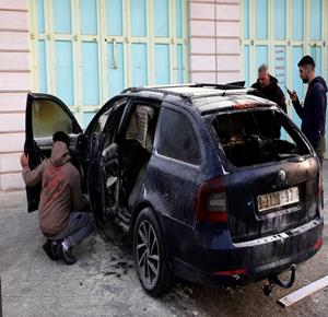 مواطنون يتفقدون مركباتهم المحترقة بعد هجوم  للمستعمرين فجر الخميس  في الخليل 